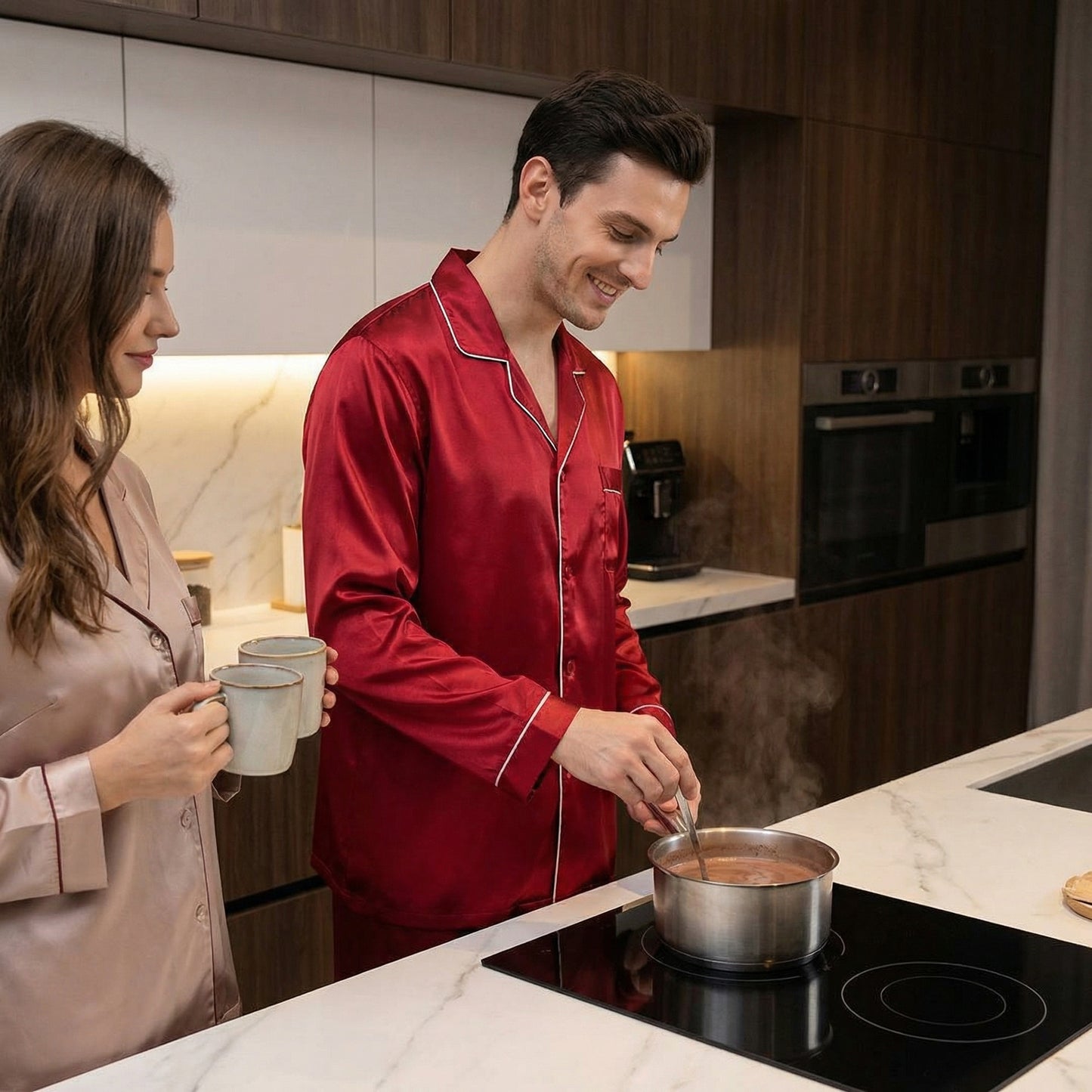 Man and woman in pajamas cooking together in a modern kitchen.
