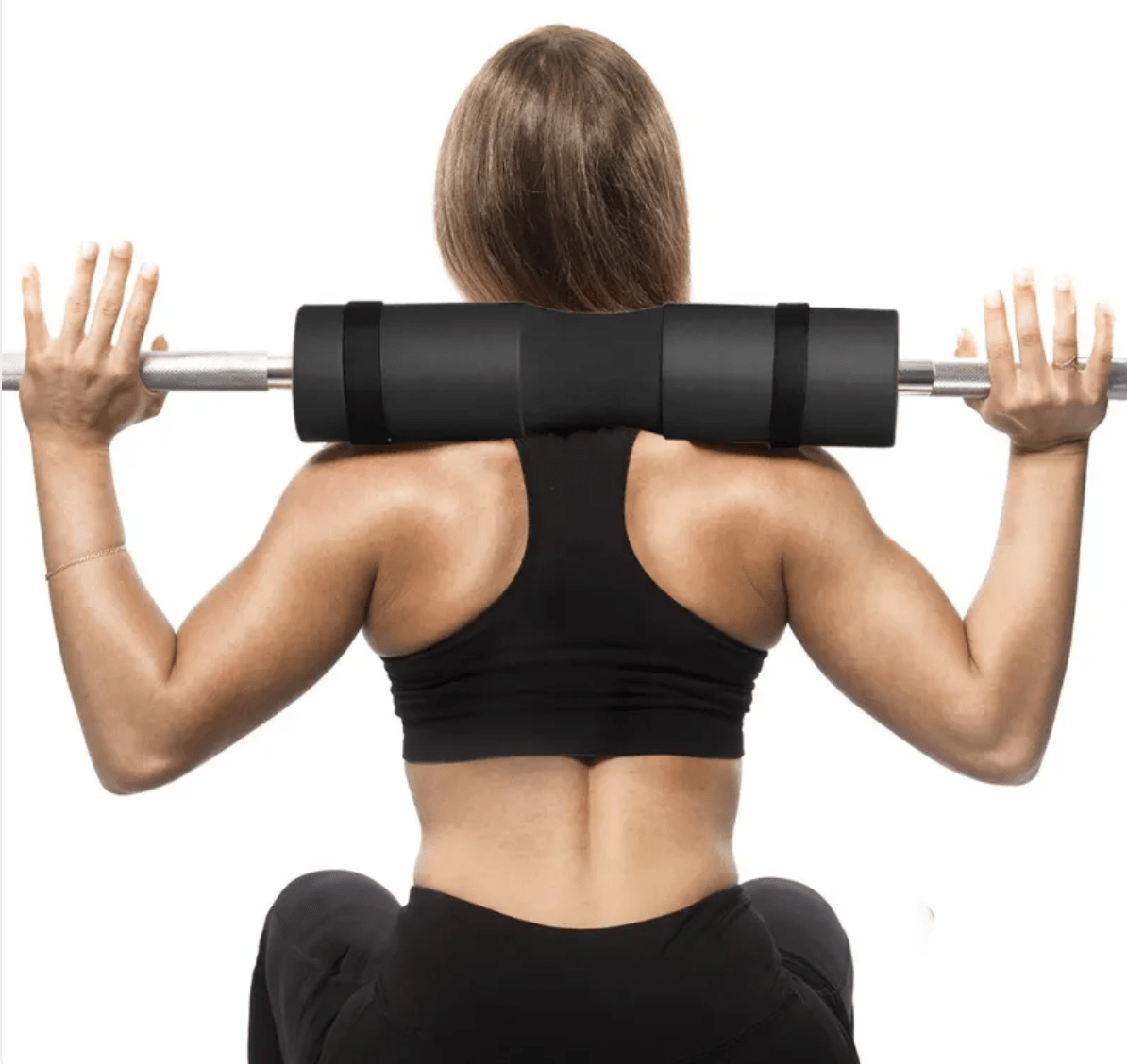Woman performing a barbell exercise on a white background