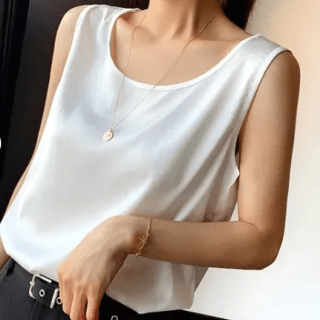 White sleeveless top worn by a person, with a neutral background