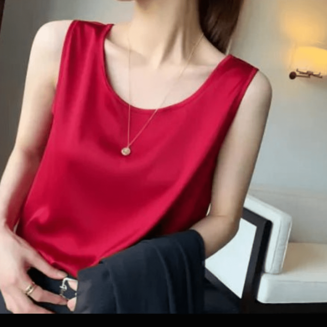 Person wearing a red sleeveless top and black pants in an indoor setting