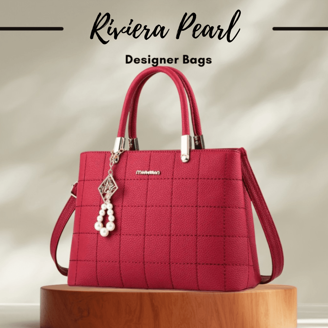 A structured red handbag with a quilted texture, dual top handles, a detachable shoulder strap, and a pearl charm, displayed on a wooden pedestal with text reading 'Riviera Pearl Designer Bags'.