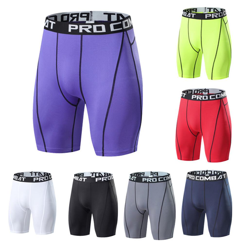 Six pairs of men's compression shorts arranged on a white background, with one large purple pair centered and five smaller color variants around it: neon yellow-green, red, white, black, and gray. Each pair has a wide waistband with visible text including 'PRO COMB' and partial brand text.