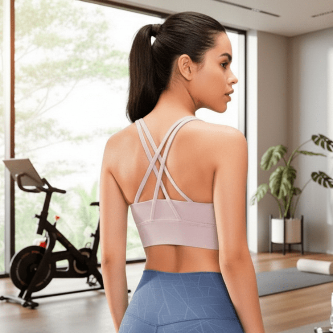 Woman in athletic wear standing in a modern indoor setting with exercise equipment.