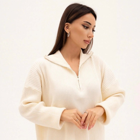Woman wearing a cream-colored sweater against a white background