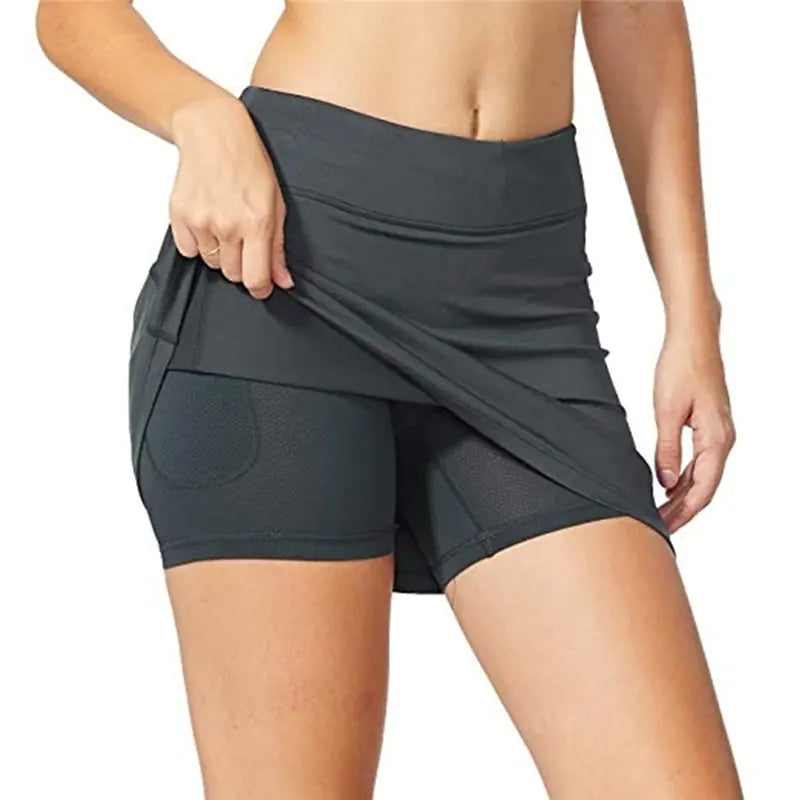 Person wearing a gray athletic skirt with a white background