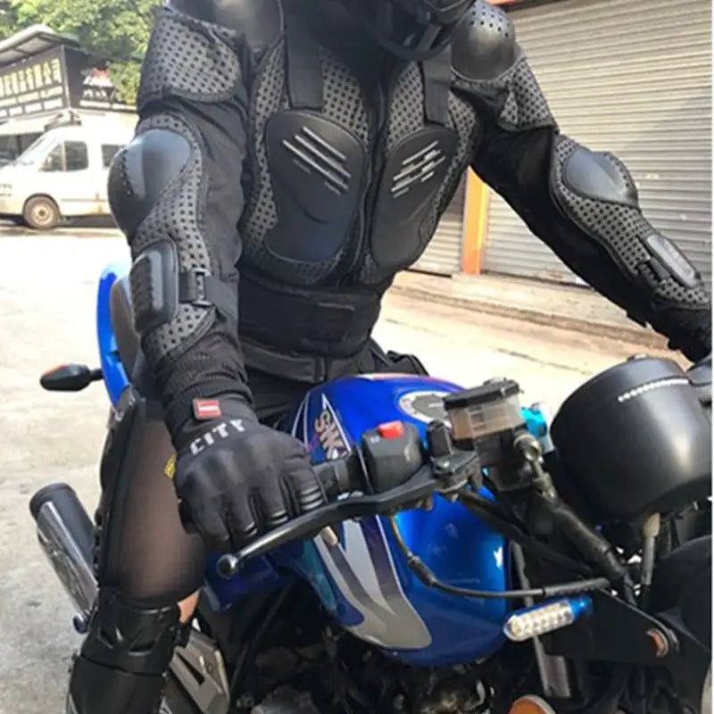 Person wearing a full-body protective suit and gloves sitting on a blue motorcycle.