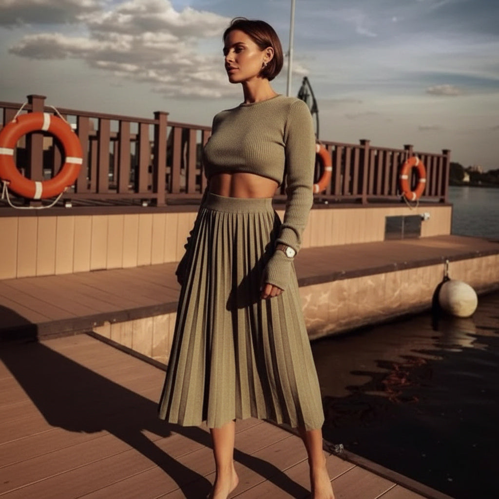 Woman in a green outfit standing on a dock with life buoys in the background