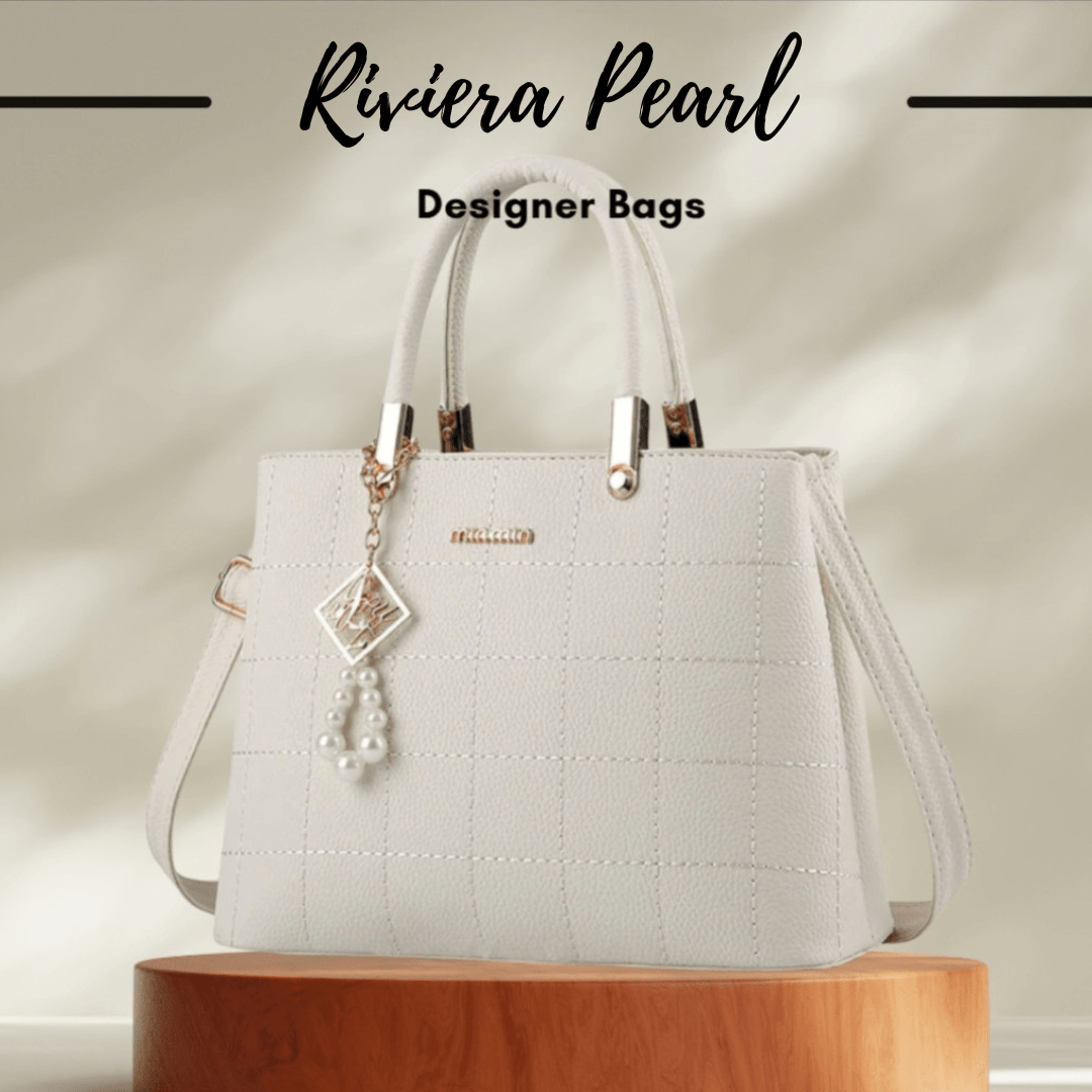 An off-white textured designer handbag with double top handles, a detachable shoulder strap, and a pearl tassel charm, displayed on a wooden pedestal with 'Riviera Pearl Designer Bags' text overlay.