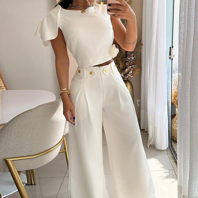 Person wearing a white outfit with ruffled sleeves in a room with light decor.