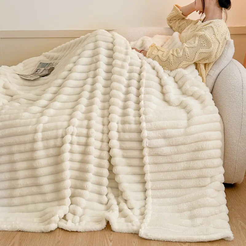 White textured blanket draped over a person sitting on a couch.